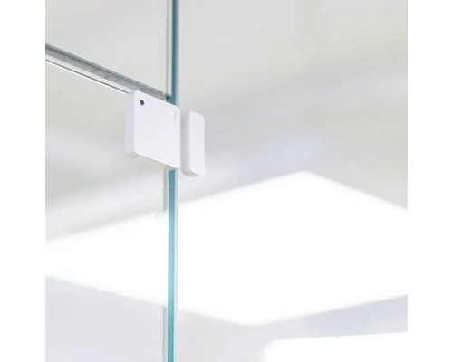 Capteur de contact de fenêtre ou de porte blanc fixé sur un panneau de verre