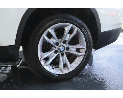 BMW Logo auf einer silbernen Alufelge während der Autowäsche