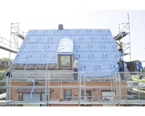 Rénovation de toit avec écran de sous-toiture sur un toit de maison, ouvriers sur des échafaudages.