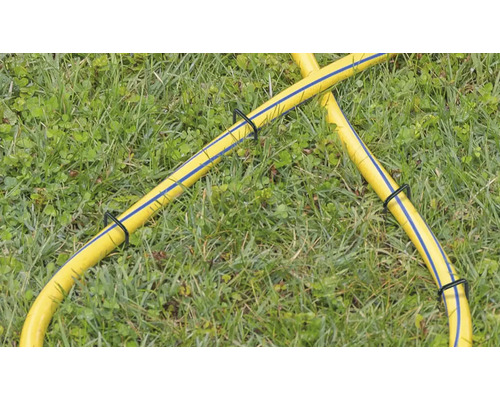 Tuyau d''arrosage jaune avec supports de tuyau dans l''herbe