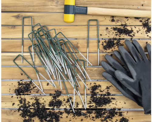 Image de jardin avec sardines, maillet en caoutchouc et gants de jardinage sur table en bois