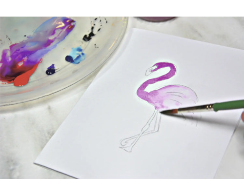 Aquarellmalerei eines Flamingos auf Papier mit Pinsel und Farbpalette
