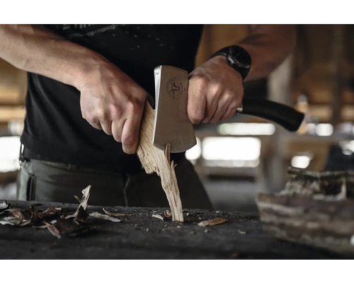 Un homme fend du bois avec une hache.