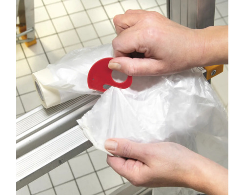 Eine Person verwendet einen roten Beutelabreißer in Elefantenform an einem Rollenständer.