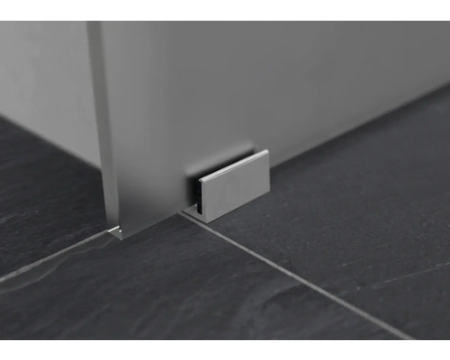 Gros plan d''un profilé de paroi de douche sur un sol carrelé foncé