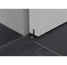 Gros plan sur un guide de porte coulissante au sol.