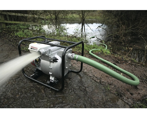 Wasserpumpe mit Schlauch im Einsatz zur Entwässerung eines überfluteten Bereichs