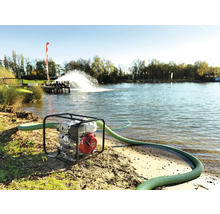 Pompe à eau avec tuyau en service au bord d''un lac