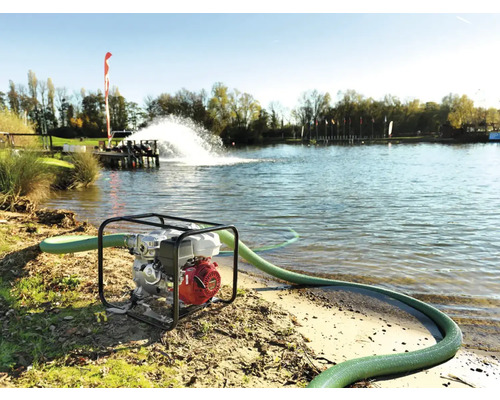 Pompe à eau avec tuyau en service au bord d''un lac