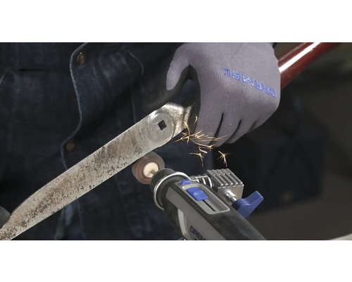 Un outil Dremel meule un disque métallique, des étincelles jaillissent.