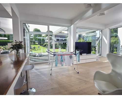 Wohnraum mit Wäscheständer, Holzboden und Blick in den Garten