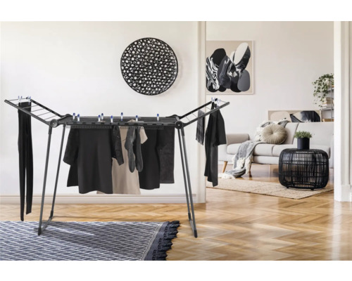 Séchoir à linge avec des vêtements suspendus dans un espace de vie lumineux.