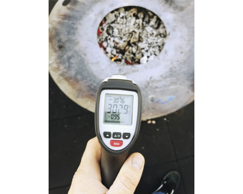 Une mesure au thermomètre infrarouge est effectuée sur un brasero avec du charbon.