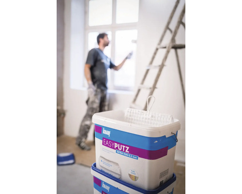 Deux seaux de Knauf Easyputz Extra Fin 0,5 mm avec peintre et échelle à l''arrière-plan
