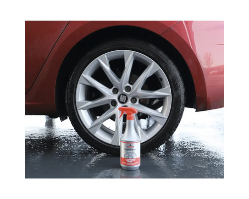 Flacon pulvérisateur de nettoyant pour jantes devant une voiture avec des jantes en aluminium