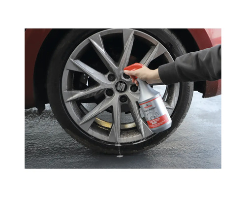 Nettoyant pour jantes en cours d''utilisation sur une roue de voiture