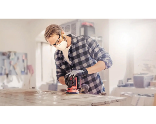 Mann schleift Tischplatte mit einem Exzenterschleifer