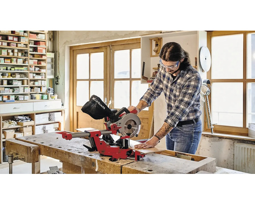 Mann schneidet Holzbrett mit einer Einhell Kappsäge in einer Werkstatt.