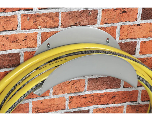 Gartenschlauch auf Schlauchhalter an einer Ziegelwand