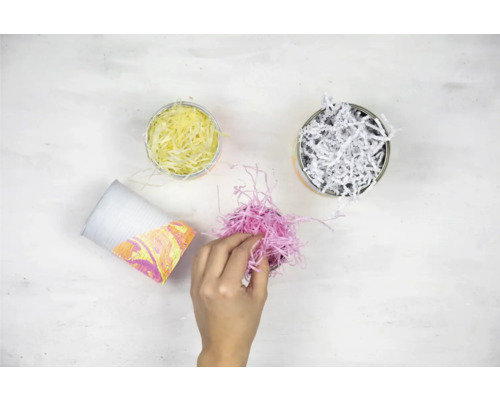 Emballage cadeau décoratif avec des bandes de papier dans des gobelets