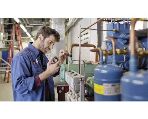 Ein Mann inspiziert eine industrielle Kälteanlage.