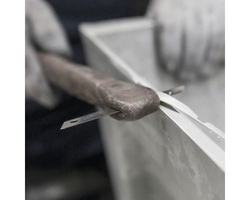 Du mastic d''étanchéité est appliqué au couteau dans un cadre de fenêtre.