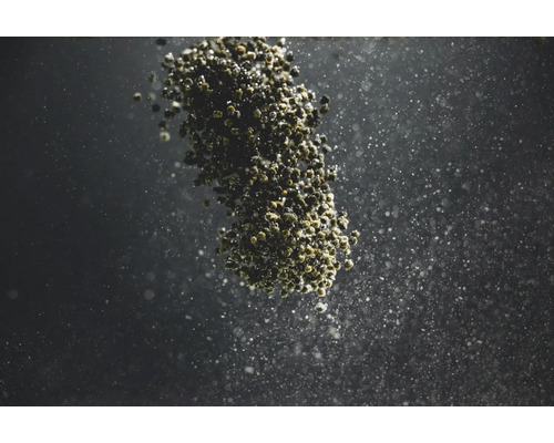 Herabfallende Düngerkügelchen vor dunklem Hintergrund