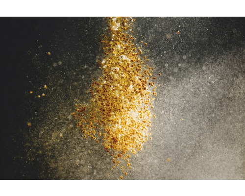 Herabfallendes Saatgut auf dunklem Untergrund.