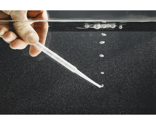 Hand hält Pipette unter Wasser