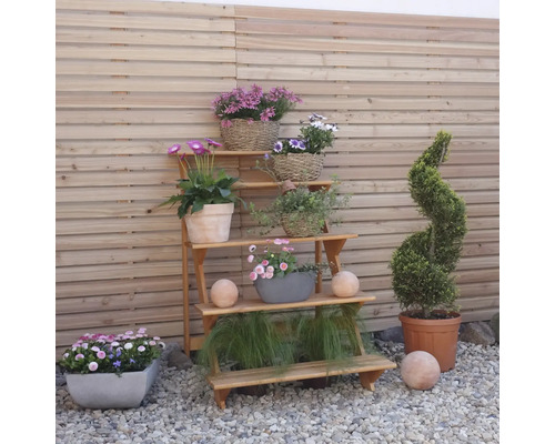 Étagère à plantes en bois avec fleurs et décoration dans le jardin