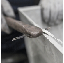Étanchéification d''un cadre de fenêtre avec du mastic et un couteau