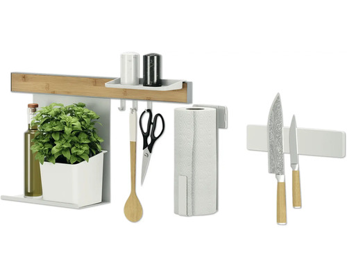 Ustensiles de cuisine sur une crédence de cuisine avec étagères et crochets, comprenant des couteaux, du papier absorbant, un pot d''herbes aromatiques, une bouteille d''huile et une cuillère de cuisine