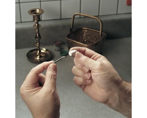 Un homme fixe un accessoire de polissage sur une perceuse pour polir le métal