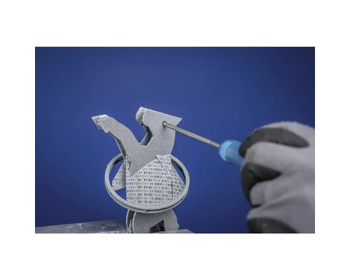 Hand mit Handschuh schraubt mit Schraubendreher an einer grauen Metallfigur