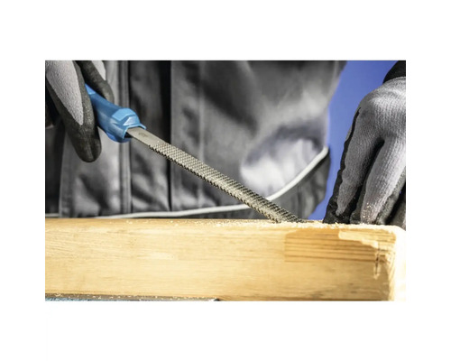Une râpe à bois est utilisée pour travailler une pièce de bois.