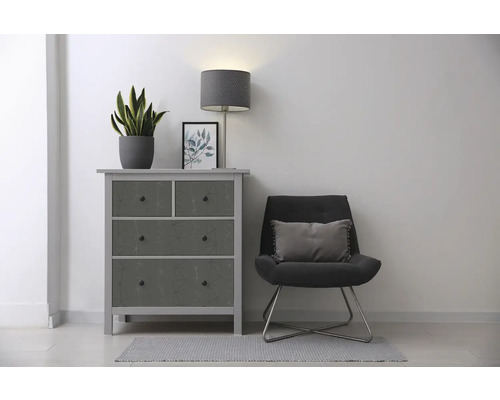 Wohnraum-Szene mit Kommode, Sessel, Lampe und Zimmerpflanze für die stilvolle Einrichtung