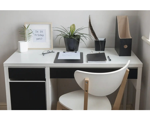 Un espace de travail lumineux avec bureau, chaise, plantes et articles de bureau.