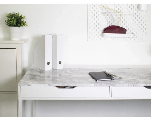 Bureau avec plateau aspect marbre, carnet et compartiments de rangement dans un bureau