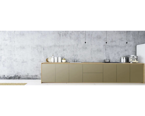 Cuisine moderne avec kitchenette, évier et appareils devant un mur en béton