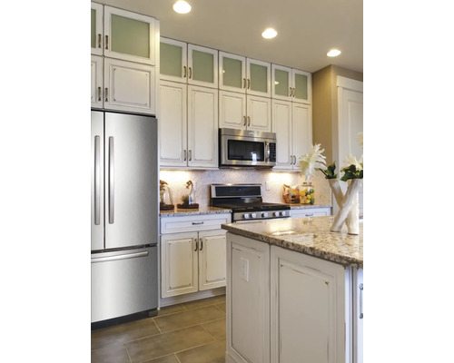 Küchenansicht mit Küchenschränken, Mikrowelle, Herd, Kühlschrank und Kücheninsel