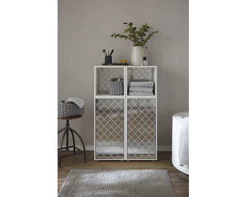 Scène de salle de bain avec un système de rangement blanc avec deux compartiments supérieurs et deux portes d''armoire inférieures, décoré avec des accessoires de salle de bain et du linge de maison