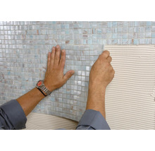 Pose de carreaux de mosaïque sur un mur