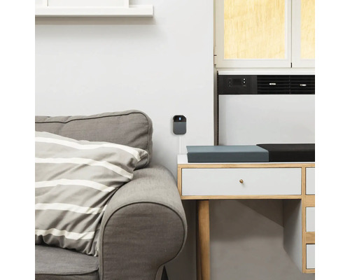 Graue Überwachungskamera an einer weißen Wand montiert