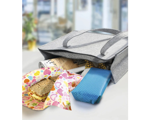 Sac en feutre gris avec des aliments emballés et un journal