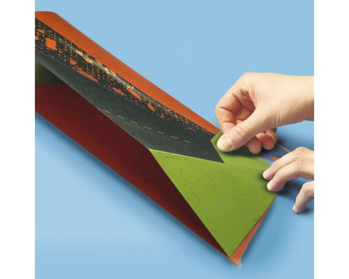 Eine Person faltet ein buntes Blatt Papier.