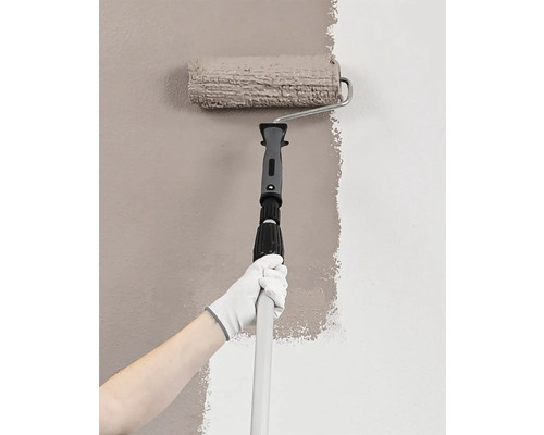 Personne peignant un mur avec un rouleau à peinture et une tige télescopique