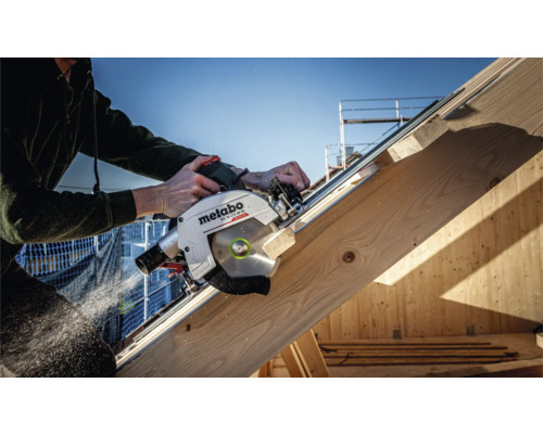 Un artisan coupe une planche de bois avec une scie circulaire Metabo.