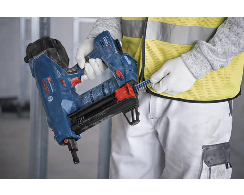 Une personne charge des agrafes dans une cloueuse pneumatique.