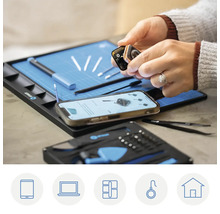 iFixit Reparaturset mit Handy, Smartwatch und Werkzeugen auf einer Arbeitsmatte.