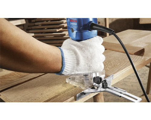 Un artisan utilise une défonceuse avec le logo Bosch sur une planche de bois